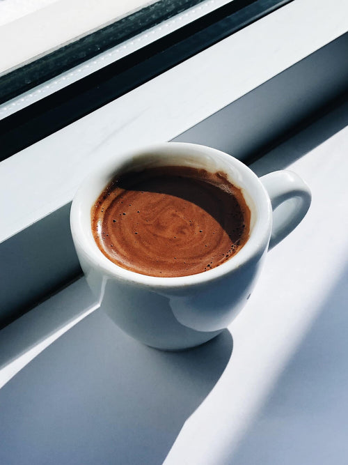 A shot of espresso on a windowsill