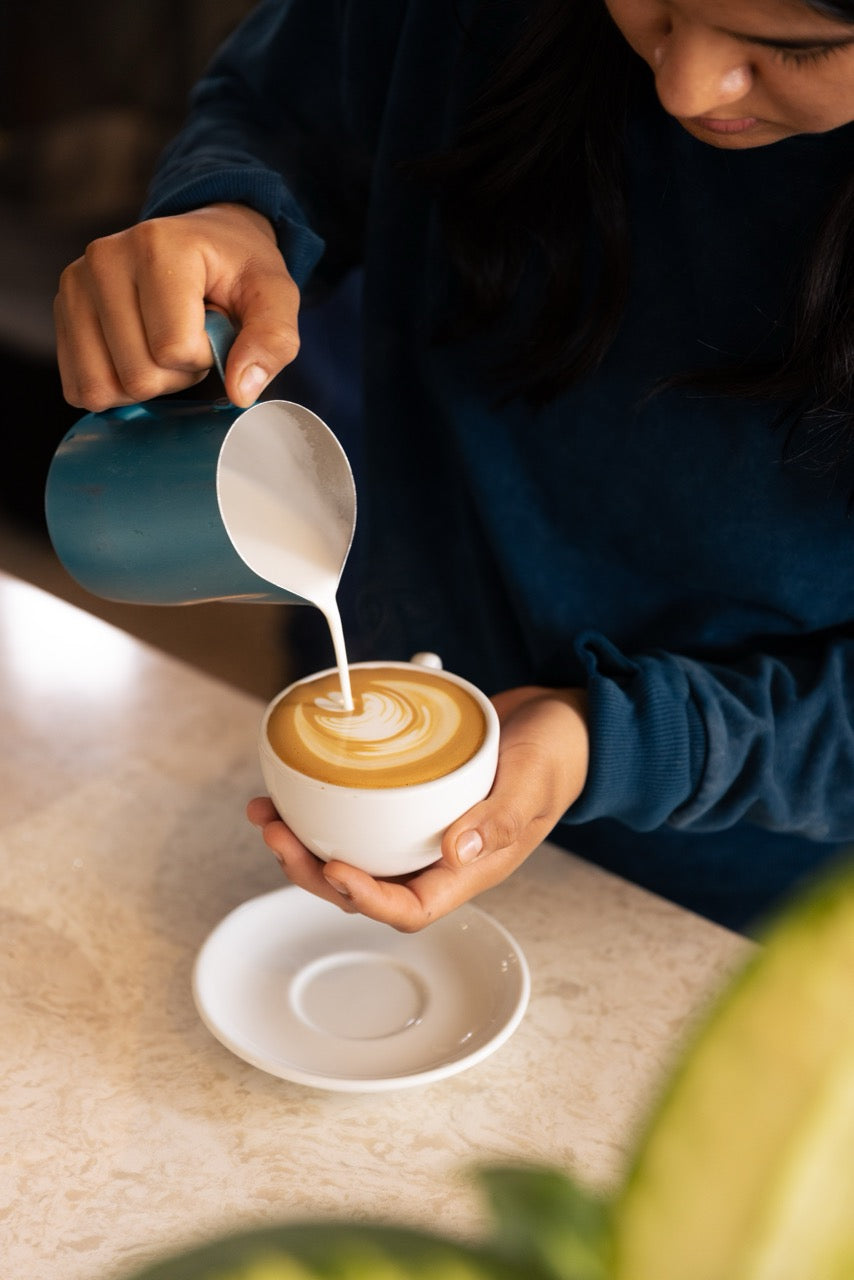 pouring the milk into the coffee 